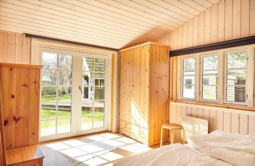 a bedroom with a bed and windows in a room at 12228-Sjaellands-Odde-Strandvaenget-23 in Yderby