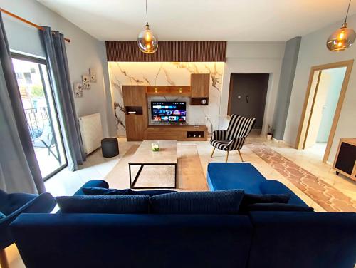 a living room with a blue couch and a tv at Meteora House with a view in Kalabaka