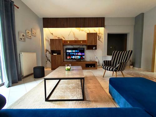 a living room with a blue couch and a table at Meteora House with a view in Kalabaka