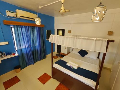 a bedroom with a bunk bed with blue walls at Serene Waters Homestay Goa in Panaji
