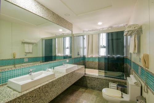 a bathroom with a sink and a toilet and a mirror at Hotel Bandeirantes in Rio de Janeiro