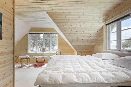 a bedroom with a large white bed in a wooden wall at 10081A-Rorvig-Skansehagevej-34 in Rørvig