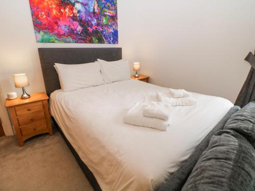 a bedroom with a white bed with towels on it at Arkwright in Matlock