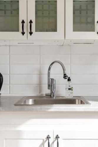 a kitchen sink with a soap bottle on it at Nordic Calm Forest Apartment in Hävla