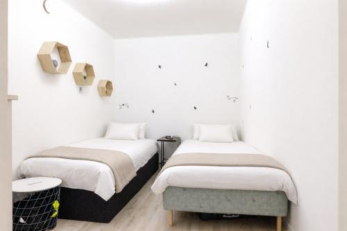 two beds in a room with white walls at Nordic Calm Forest Apartment in Hävla