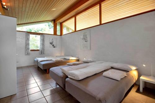 a room with three beds in it with windows at 12253-Nykobing-Sj-Aeblehegnet-7 in Tjørneholm