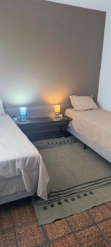 two beds in a room with two lamps on tables at 203 Barra Refúgio in Tramandaí
