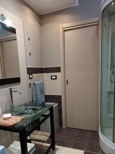 a bathroom with a glass sink and a shower at Casa Letizia in Lercara Friddi