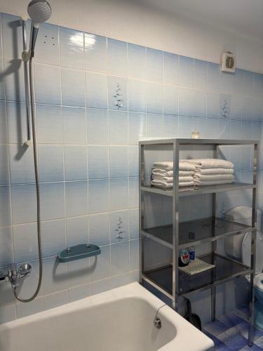a bathroom with a bath tub and a shelf with towels at Apartman Seven Kaštel Stari in Kaštela