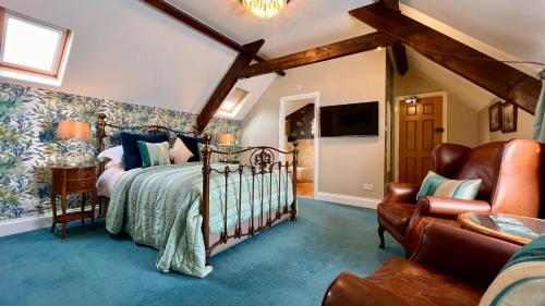 a bedroom with a bed and a couch and a chair at The Mainstay Luxury Boutique Rooms with Private Parking in Whitby