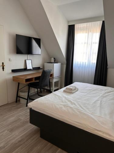 ein Schlafzimmer mit einem Bett und einem Schreibtisch mit Computer in der Unterkunft Hotel Zum Studio in Hamburg