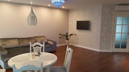 a living room with a table and a couch at Apartament Smilčių skg in Palanga