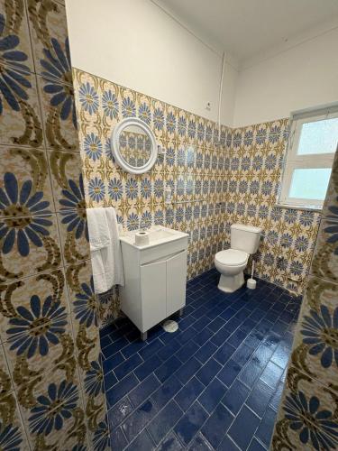 a bathroom with a toilet and a sink and a mirror at Alojamento Local Santo António in Montemor-o-Velho
