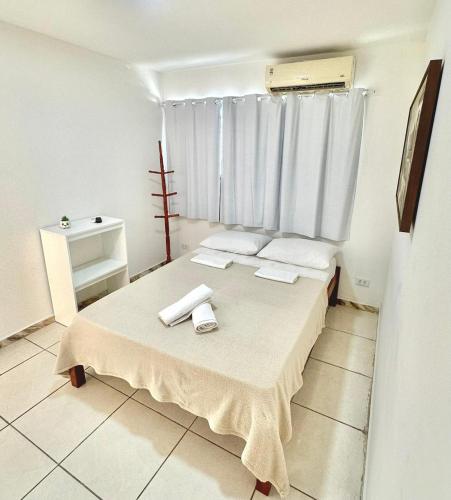 a bedroom with a bed with two towels on it at Quarto 01 - Pousada Canaã in Recife