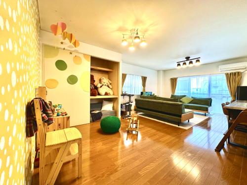 a living room with a green couch and a table at Villa Kokubunji Stay in Kokubunji
