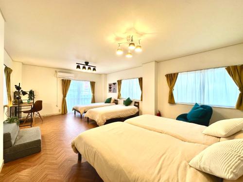 a hotel room with two beds and a couch at Villa Kokubunji Stay in Kokubunji