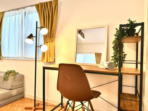 a desk in a room with a chair and a mirror at Villa Kokubunji Stay in Kokubunji