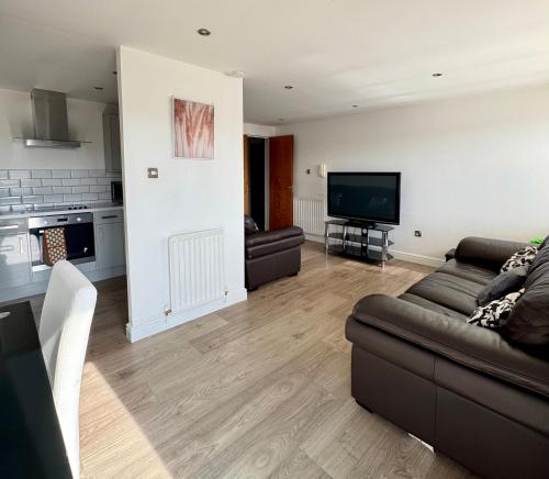 a living room with a couch and a flat screen tv at Modern 2 Bedroom 2 Bathroom City Apartment Free Parking in Newcastle upon Tyne