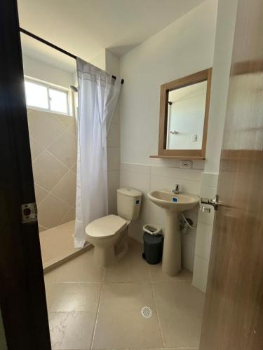 a bathroom with a toilet and a sink and a shower at Adele Hotel in Ríohacha