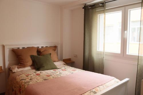 a small bedroom with a bed with a window at Pretodomar3 in A Coruña