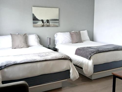 two beds sitting next to each other in a bedroom at Motel Cabano-Relais in Cabano