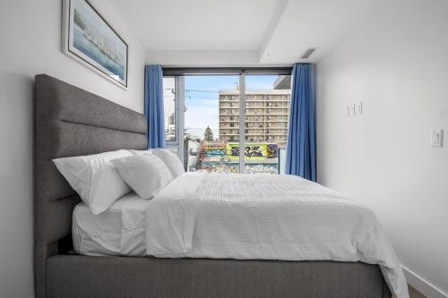 a bedroom with a bed and a large window at Stylish Serenity 1BR Kensington Condo wParking in Calgary