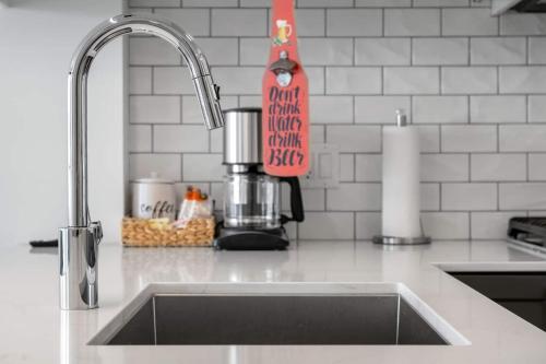 a kitchen counter with a sink and a mixer at Stylish Serenity 1BR Kensington Condo wParking in Calgary
