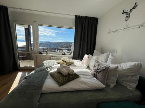 a large bed in a bedroom with a large window at Bergidylle Simonhöhe, Kärnten in Zirkitz