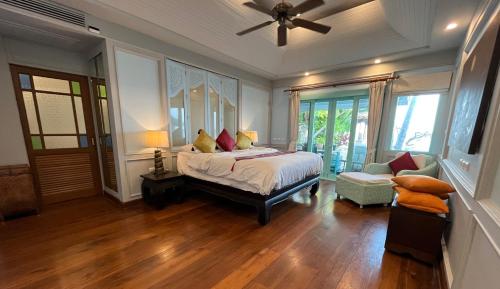 a bedroom with a bed and a ceiling fan at Villa Sunrise - Golden Beachfront in Nathon Bay