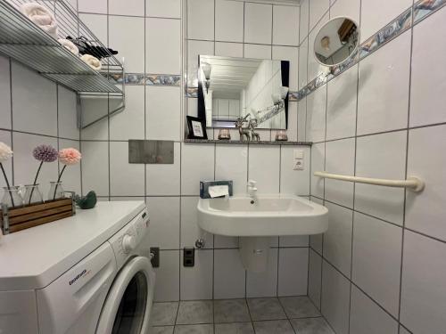 a white bathroom with a sink and a washing machine at Bergidylle Simonhöhe, Kärnten in Zirkitz