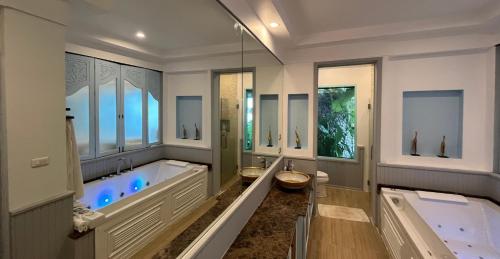 a large bathroom with a tub and two sinks at Villa Sunrise - Golden Beachfront in Nathon Bay
