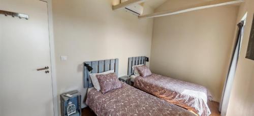 two beds sitting next to each other in a room at Casa do Almance in São João