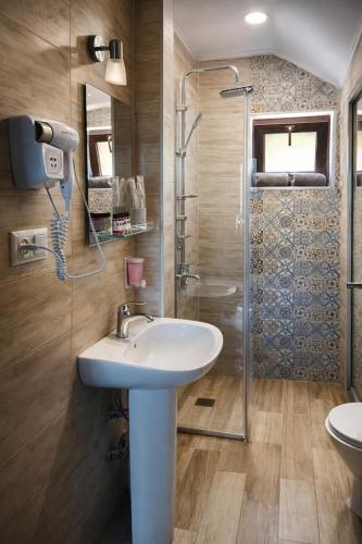 a bathroom with a sink and a shower at Fortuna Cottage Bakuriani in Bakuriani