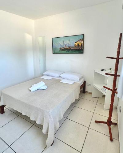 a white room with a bed and a desk at Quarto 02 - Pousada Canaã in Recife