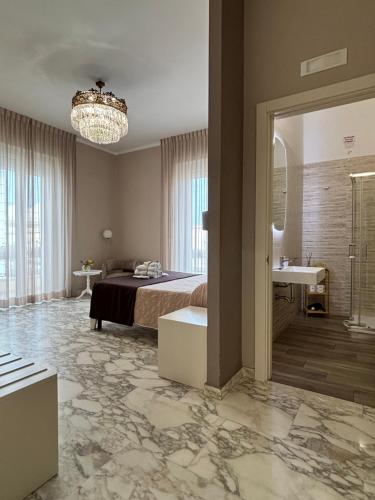a bedroom with a bed and a bathroom with a sink at Faro Bianco Gallipoli - Suites & Apartments in Gallipoli