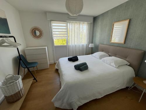 a bedroom with a large bed with two bags on it at Appartement vue mer in Bénodet