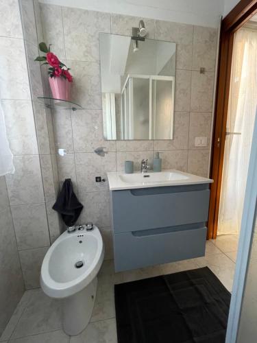 ein Badezimmer mit Waschbecken, Toilette und Spiegel in der Unterkunft Piccolo Relax in Meina