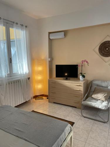 ein Schlafzimmer mit Bett, Fernseher und Stuhl in der Unterkunft Piccolo Relax in Meina