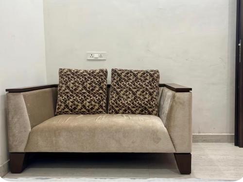 a brown couch sitting in a room at Bliss in Datia