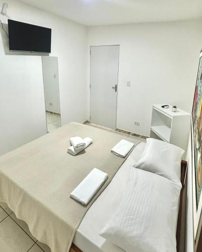 a room with a table with white towels on it at Quarto 03 - Pousada Canaã in Recife