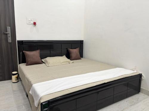 a bedroom with a large bed with a black headboard at Bliss in Datia