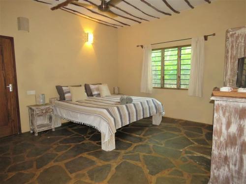 a bedroom with a large bed in a room at 1, 2 bed bungalow Watamu in Watamu