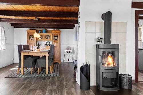 a fireplace in a living room with a dining room table at LF10304-Hurup-Thy-Gundtoft-Mollevej-4 in Gettrup