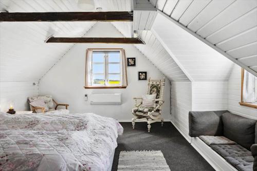 a attic bedroom with a bed and a chair at LF10304-Hurup-Thy-Gundtoft-Mollevej-4 in Gettrup
