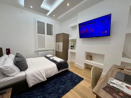 a bedroom with a bed and a tv on the wall at Stockwell Residences - The Eclipse Room in London