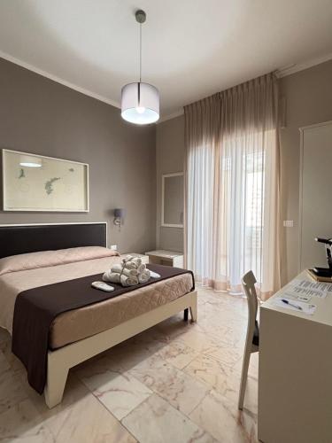 a bedroom with a bed and a table and a desk at Faro Bianco Gallipoli - Suites & Apartments in Gallipoli