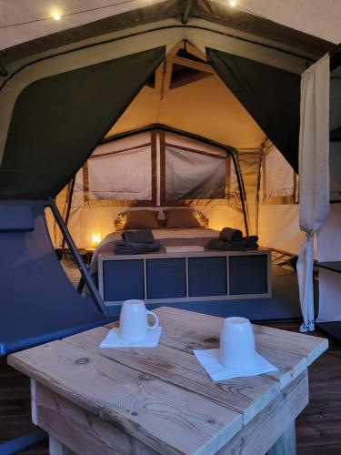 two hats on a wooden table in a tent at Camping La Charderie in Pont-de-Labeaume