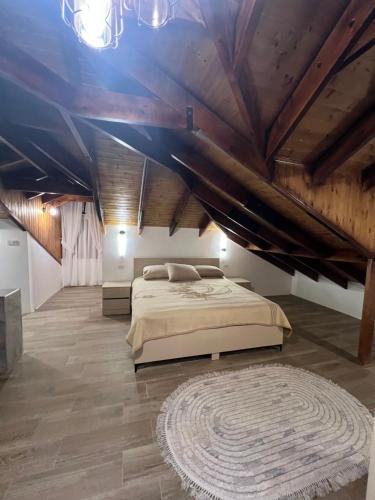 a bedroom with a large bed and wooden ceilings at Bait Ajloun in Khirbat Shīn