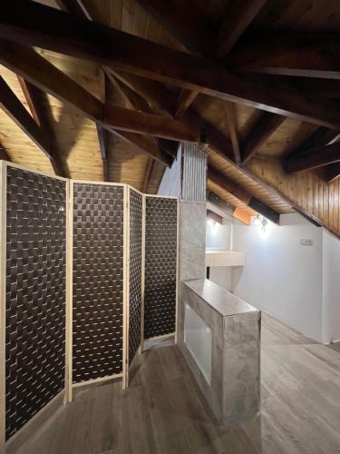 a room with a stone wall and a wooden ceiling at Bait Ajloun in Khirbat Shīn
