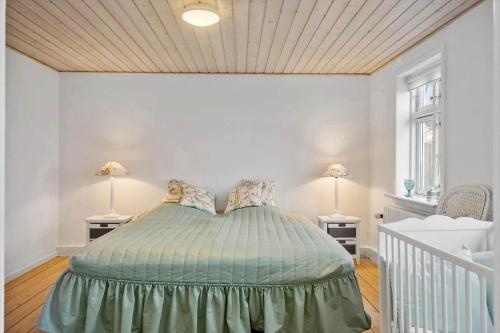 a bedroom with a bed and two lamps on two tables at LF11975-Struer-Havstokken-12 in Vemb